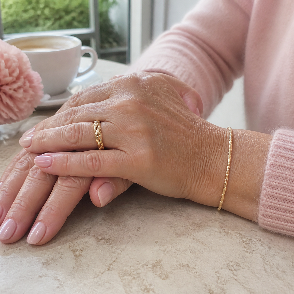 Kvinna som bär en guldring och ett tunt armband